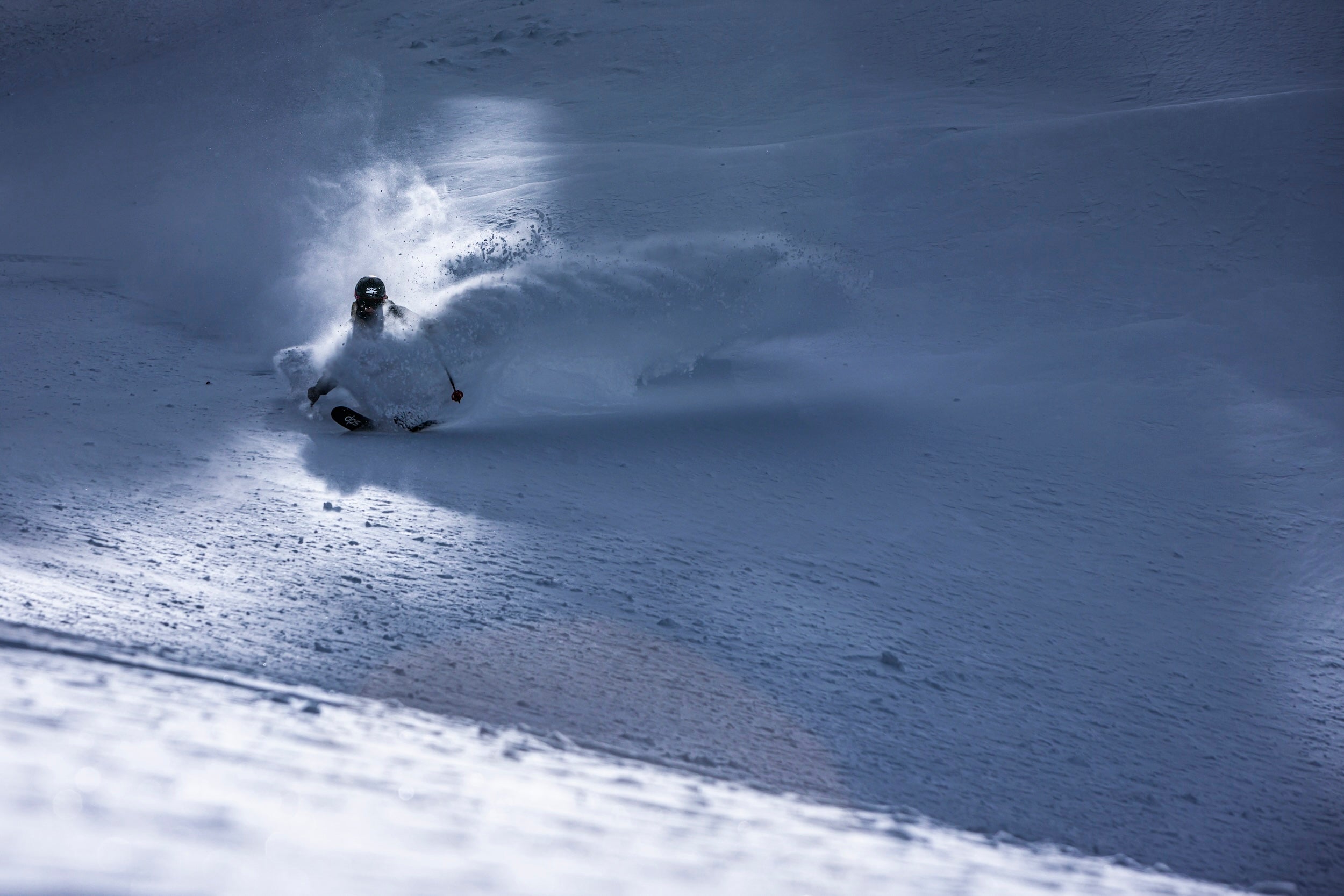 Person skiing in deep snow on a mountain slope